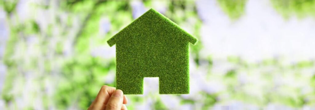 casa sustentável - objeto em formato de casa verde segurado por uma mão